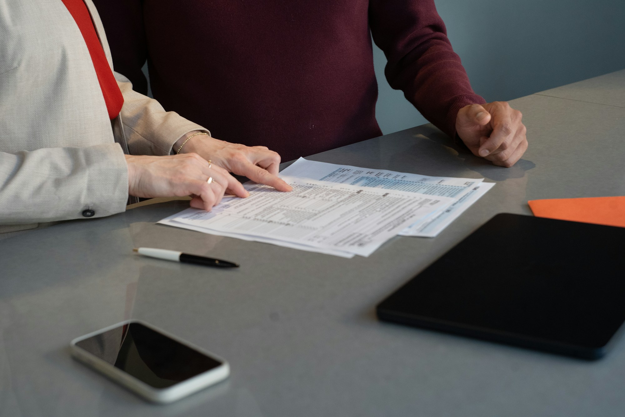Two business professionals carefully reviewing documents